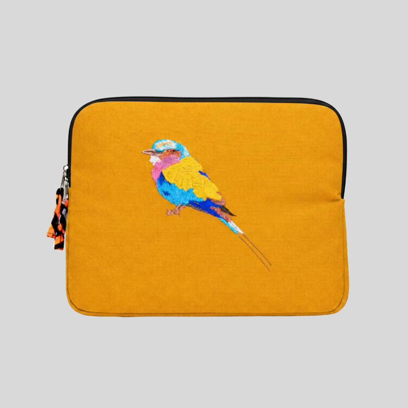 Yellow laptop sleeve with a colorful bird design on a gray background