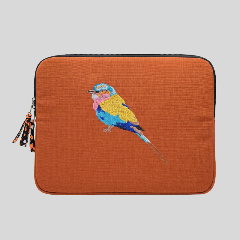 Orange laptop sleeve with a colorful bird design on a gray background