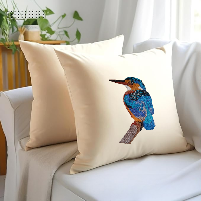 Naural pillow cover with a Bird Embroidery on a beige couch.