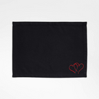 Black Tablemat with red heart embroidery on a white background