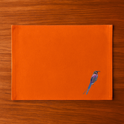  Burnt Orange  with a bird embroidery  on a wooden surface