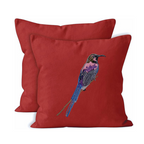 Red pillow with embroidered bird design on a white background