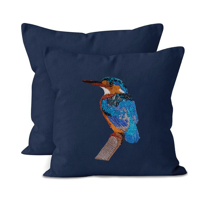 Navy blue pillow with embroidered bird design on a white background