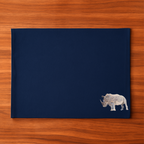 Navy blue placemat with a rhino design on a wooden surface