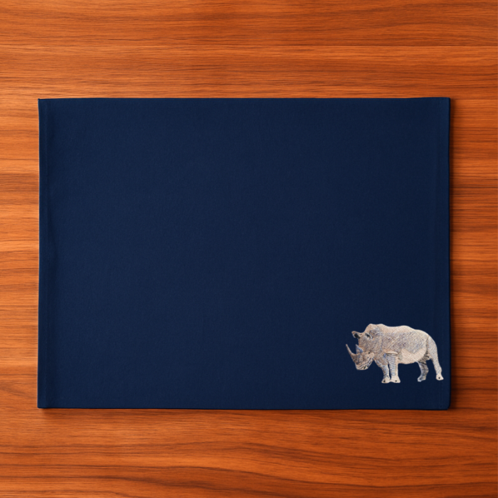 Navy blue placemat with a rhino design on a wooden surface