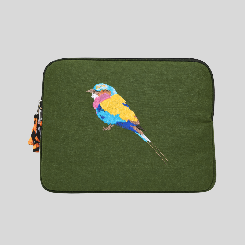 Green laptop sleeve with a colorful embroidered bird design on a gray background
