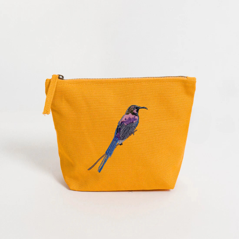 Yellow pouch with a an embroidery bird design on a white background