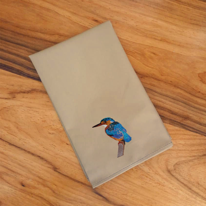 Brown table napkins  with an embroidered  bird on a wooden surface