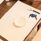 Natural Tablemat with a bird embroidery on a wooden table.