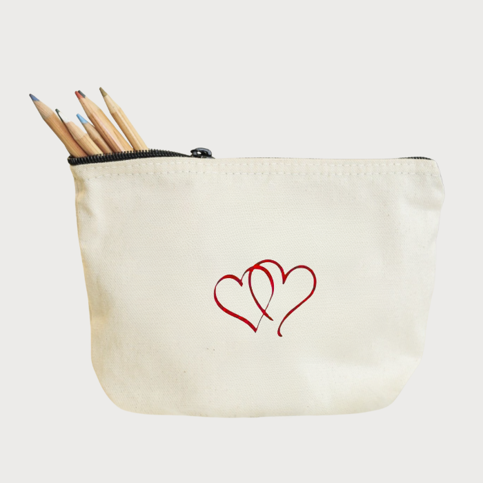 Beige pouch with red hearts embroidery and pencils on a white background