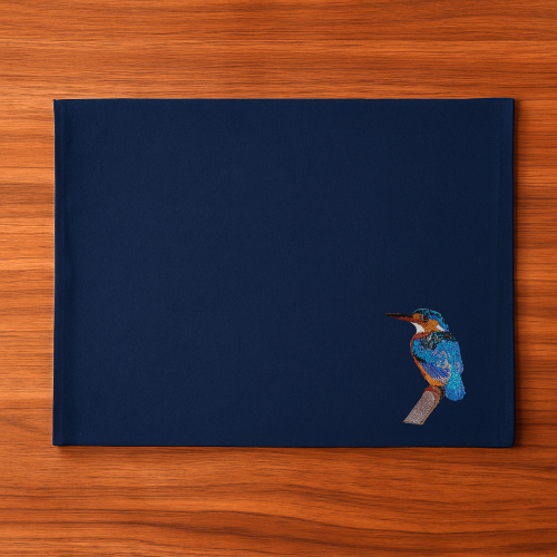Navy blue Tablemat with an embroidered bird  on a wooden surface