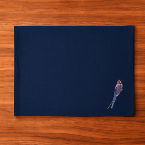Navy blue Tablemat with a embroidered bird  on a wooden surface