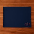 Navy blue placemat with red heart embroidery on a wooden surface