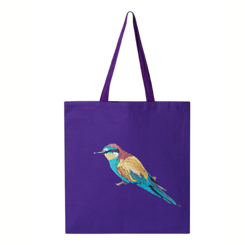 Purple tote bag with a bee eater bird embroidery on a white background