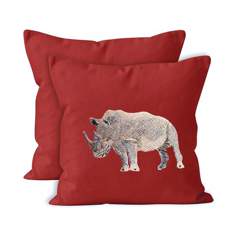 Red pillows with embroidered rhino design on a white background