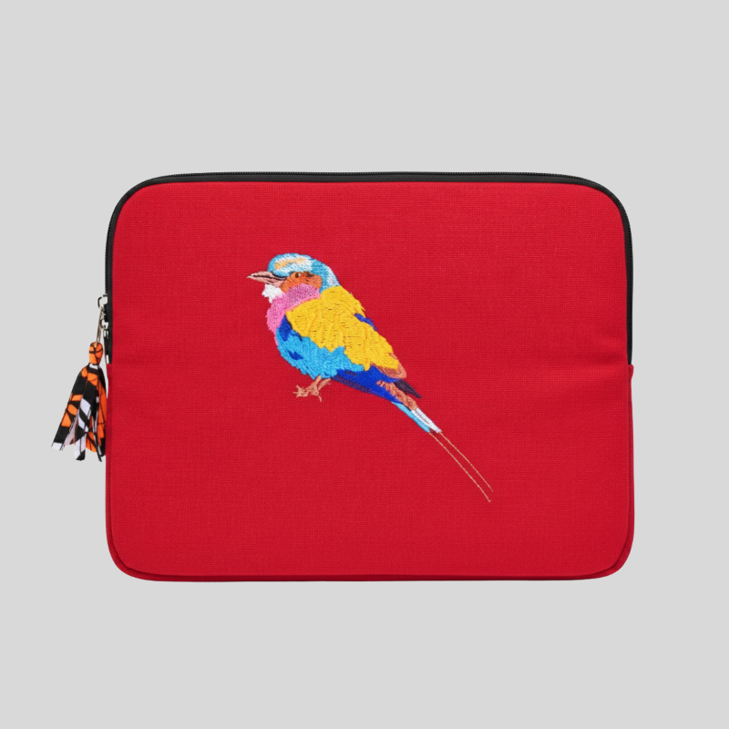 Red laptop sleeve with a colorful bird design on a gray background