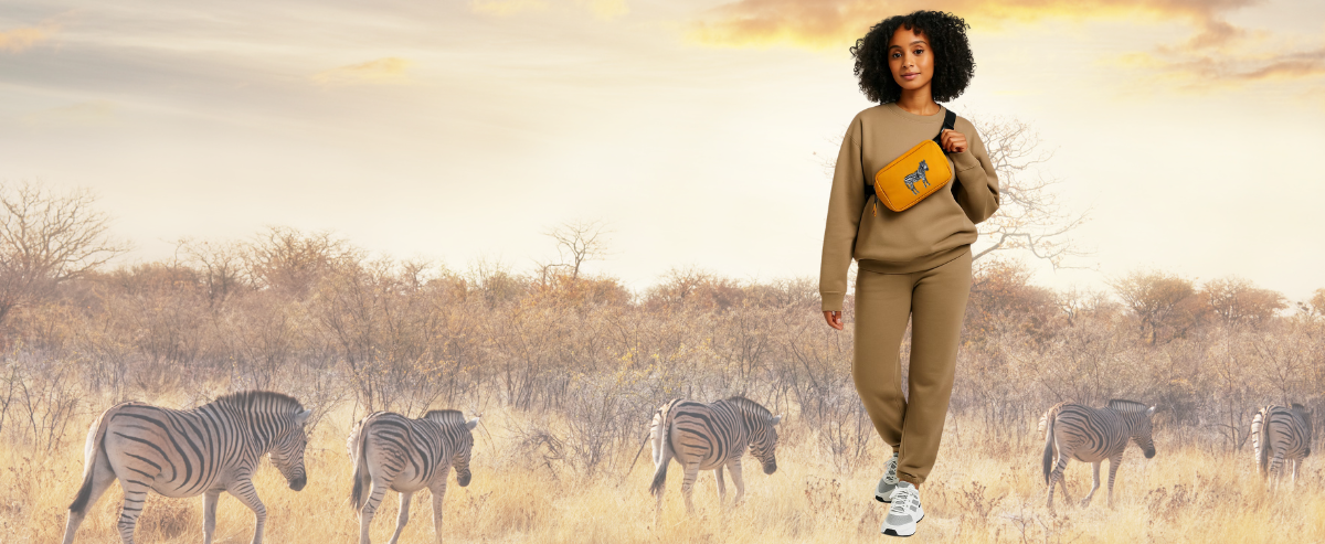 Woman in a safari outfit with zebras in the background