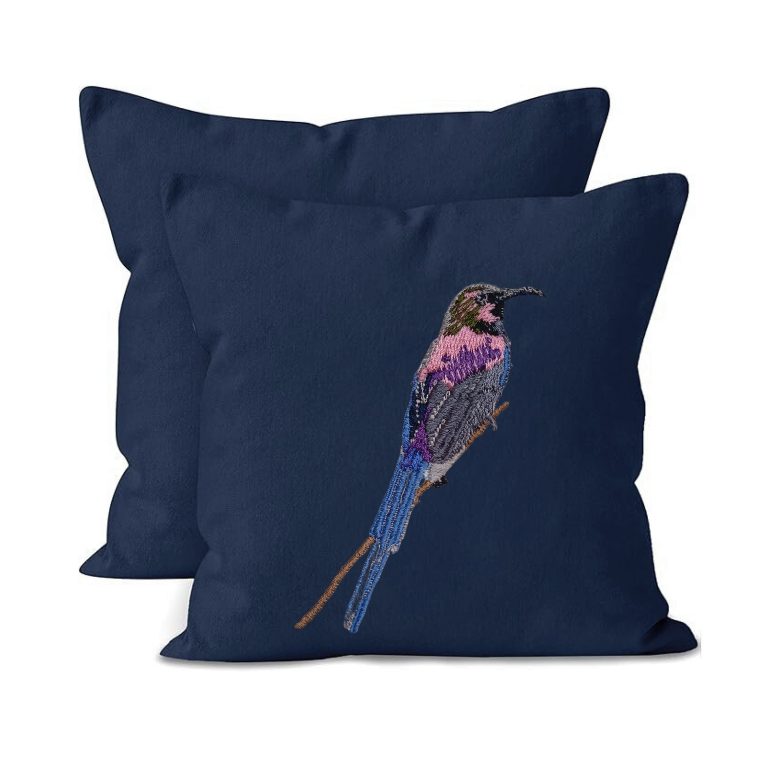 Navy blue pillow with embroidered bird design on a white background