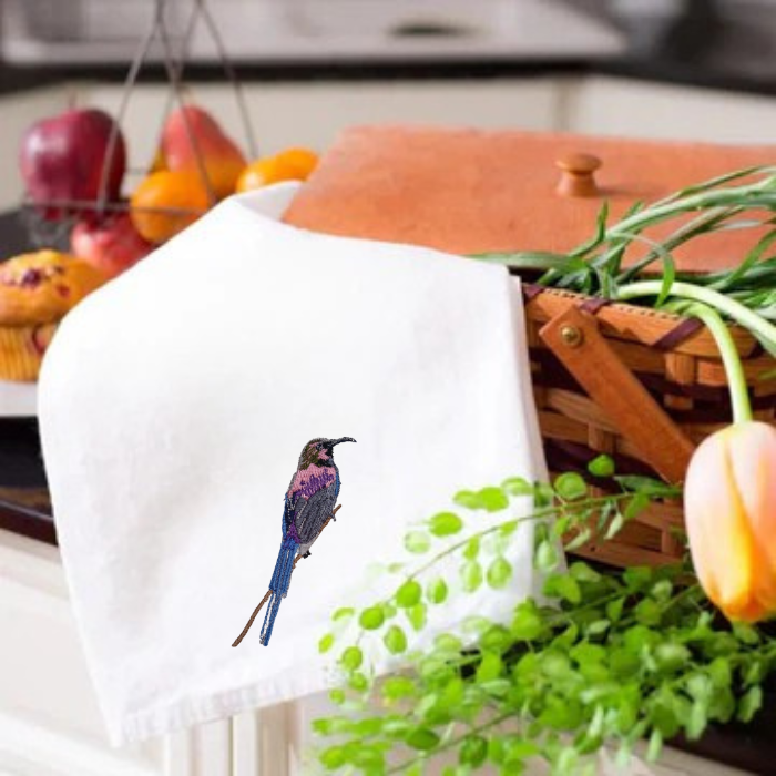 White Kitchen tea  towel with a bird embroidery on a table 