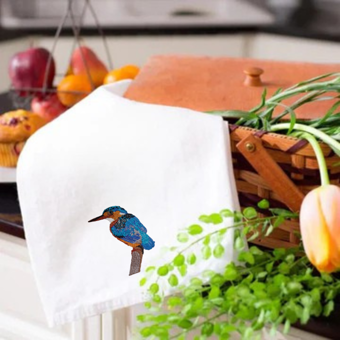 White kitchen tea  towel with a bird embroidery on a kitchen counter 