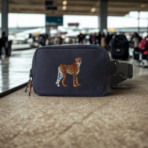 Navy blue belt bag with a cheetah design on a blurred airport background