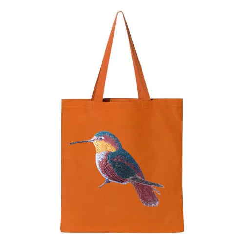 ILISAH Canvas Tote featuring a vibrant hummingbird design, available in black, burnt orange, and navy blue, perfect for ev...