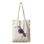 ILISAH Canvas Tote featuring a vibrant hummingbird design, available in black, burnt orange, and navy blue, perfect for ev...