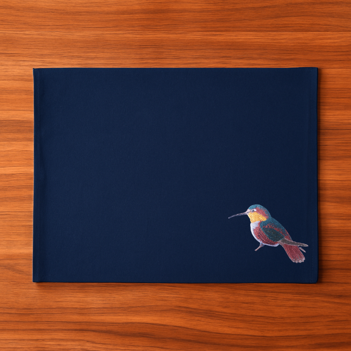 Navy blue cloth placemat with a hummingbird embroidery design