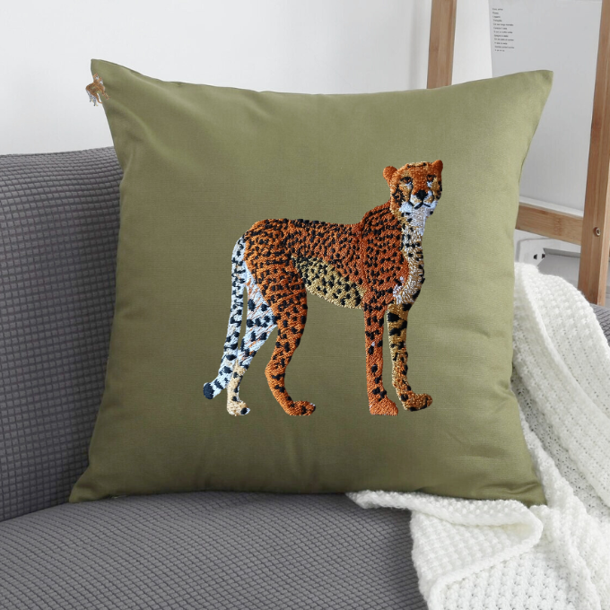 Green pillow with a cheetah design on a gray couch.