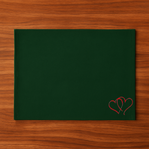 Green tablemat with red heart embroidery on a wooden surface