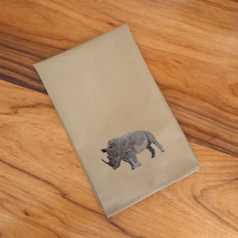 Handmade cotton napkins with rhino embroidery by Ilisah, available in brown khaki and beige white, perfect for dining tables.