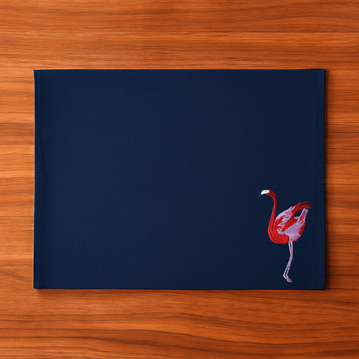 Navy blue placemat with a pink flamingo embroidery design 