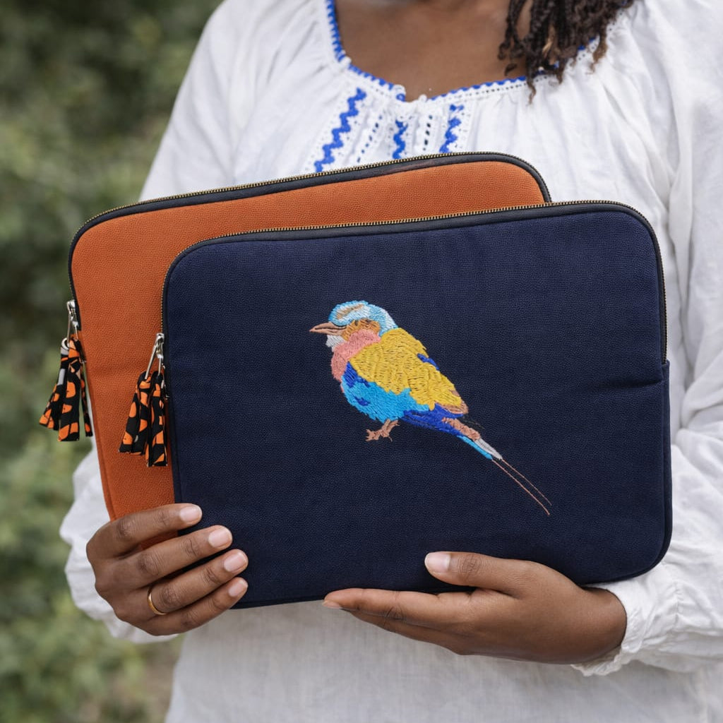 Woman holding  embroidered laptop sleeves with a bird design outdoors