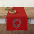 Wreath Motif Table Runner by ILISAH in red, featuring acorn embroidery and a festive design, perfect for Christmas table s...